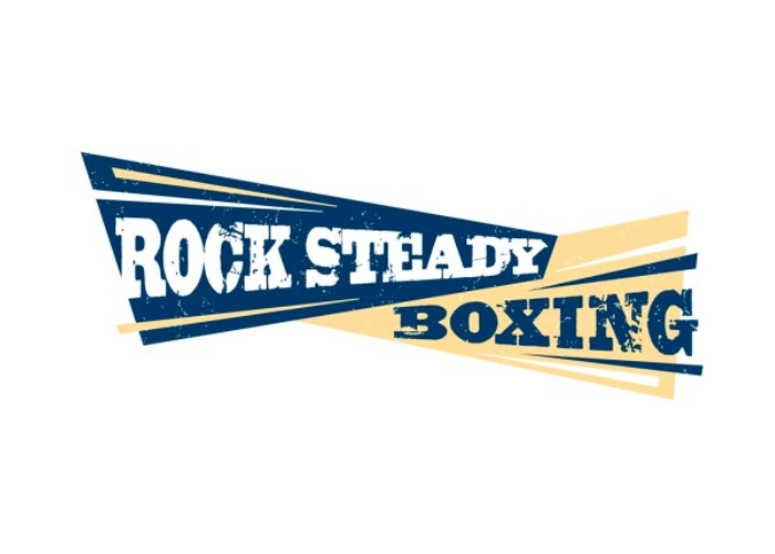 The Rock Steady Boxing logo. The words are in a weathered bold serif font and "Rock Steady" is in a blue narrow triangle shape while "Boxing" is in a matching yellow shape.