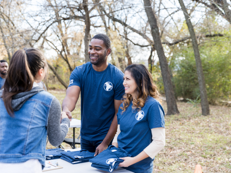 A male and a female volunteer handing out t shirts