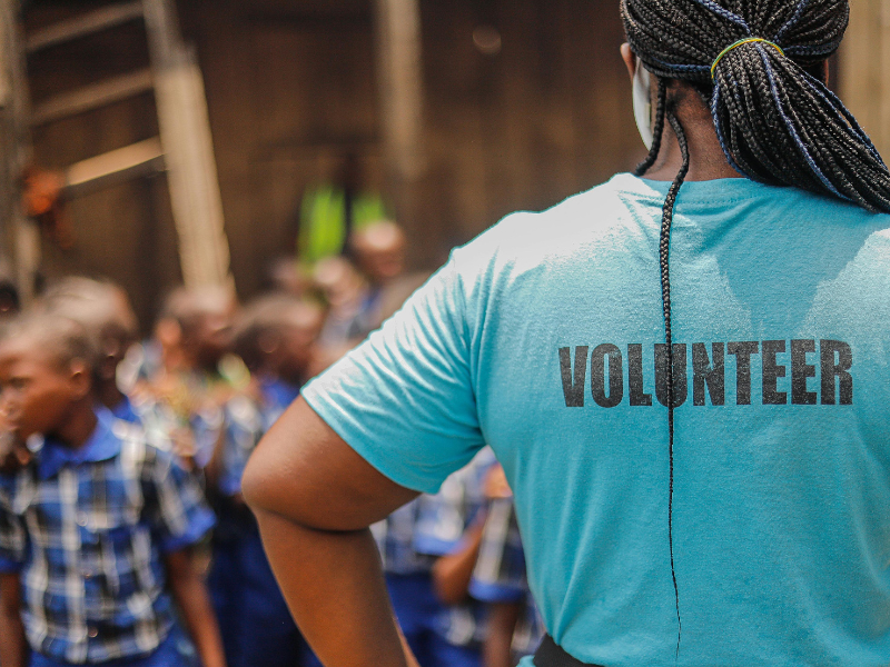 A woman with braids wearing a volunteer t shirt