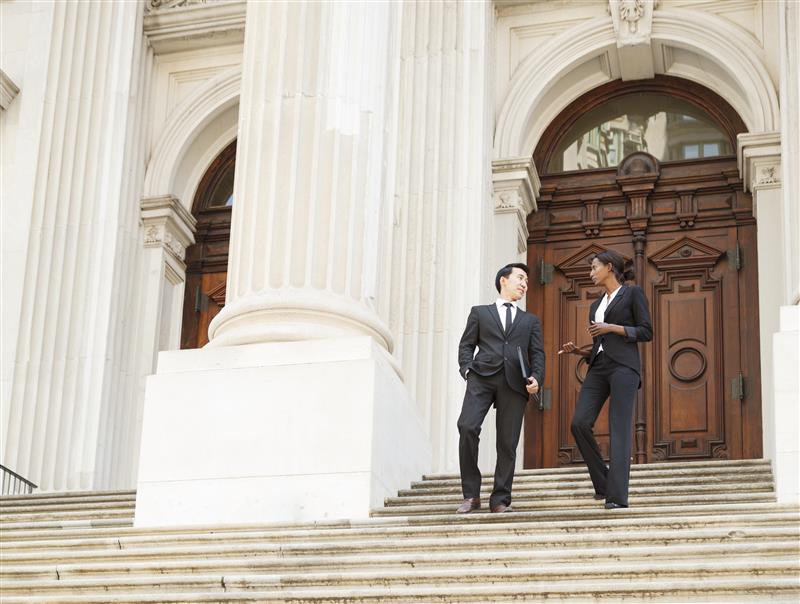 Professionals walking down courthouse steps after a legislative meeting, representing nonprofit lobbying and advocacy efforts.